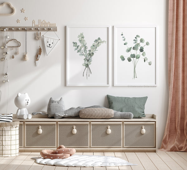 Dieses Set aus zwei Drucken in weißen Rahmen mit minimalistischen Aquarell-Eukalyptusmotiven auf weißem Hintergrund hängt in einem modernen skandinavischen Kinderzimmer. Die zarten Eukalyptuszweige, in sanften Grüntönen gehalten, verleihen dem Raum eine ruhige und natürliche Atmosphäre. Die schlichten weißen Rahmen und das minimalistische Design passen perfekt zum klaren und luftigen Stil des skandinavischen Interieurs, wodurch der Raum hell und freundlich wirkt. Ideal für ein Kinderzimmer.