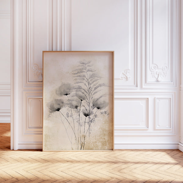 A framed botanical print of black poppies against a white paneled wall with decorative molding. The print features stylized gray flowers with thin black stems and a central feathery branch, rendered in a watercolor style against a textured, off-white background. The frame is a thin, light-colored wood. The wall has a classic design with raised panels, decorative trim, and floral motifs. The floor is a herringbone pattern of light and medium wood.