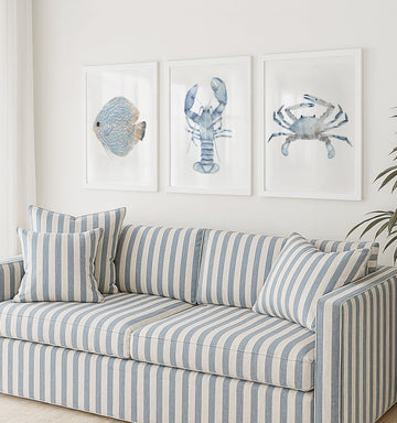 minimalist coastal prints hang above striped coach