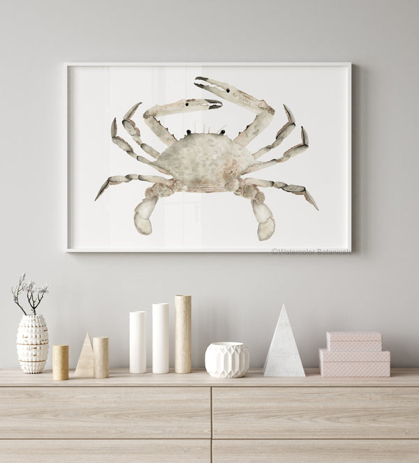 A framed watercolor painting of a realistic crab in soft, earthy brown tones hangs on a wall above a console table with decorative objects.