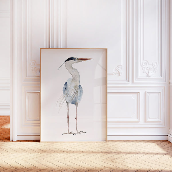 A watercolor painting of a minimalist large heron adds a touch of nature to a room with a wood floor, ornate molding, and white walls.