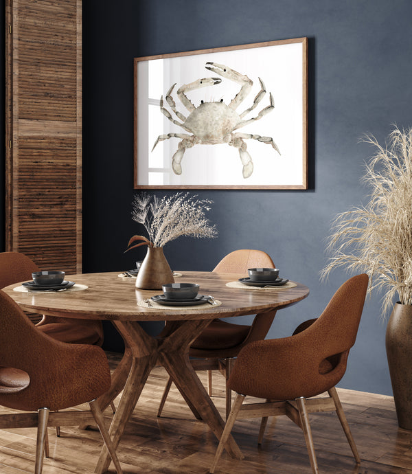 A large, framed watercolor painting of a realistic crab in soft, earthy brown tones hangs on a deep blue wall above a round wooden dining table in a modern dining room.