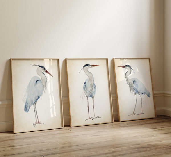 3 large wooden frames with great blue herons painted on vintage backgrpund are leaning towards the wall