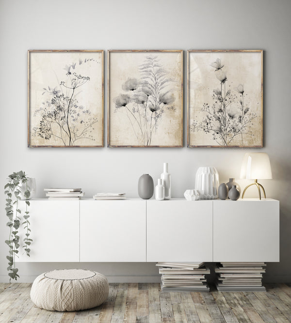 Watercolor paintings of black floral elements add a touch of nature to a living room with a white console table, a round pouf, and decorative objects.