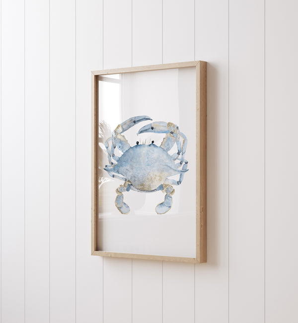 A framed watercolor painting showcases the intricate details of a blue crab, its textured shell and spindly legs rendered with delicate precision, viewed from an angled perspective.