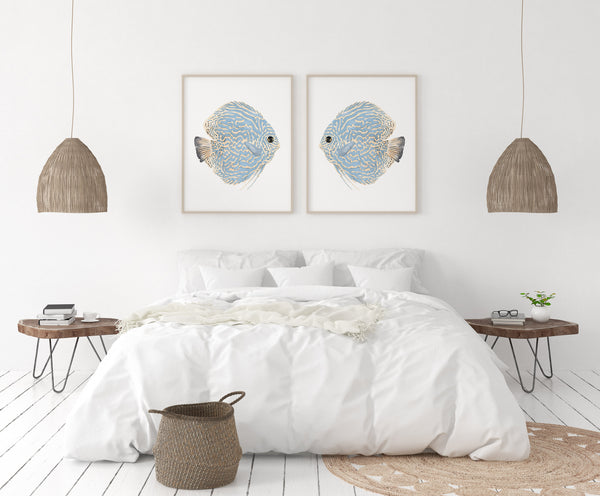Minimalist coastal wall decor depicting watercolor blue discus fishes in modern beach house bedroom above large king size bed
