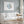 Watercolor minimalist large fish in blue color hang above a white couch in a modern coastal living room.
