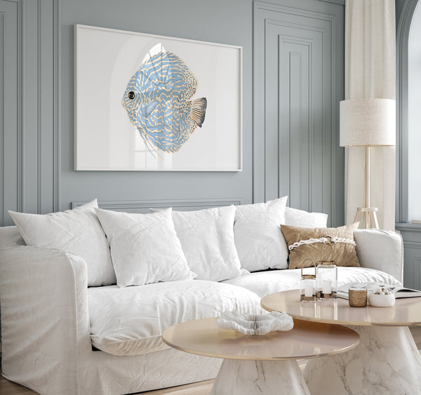 Watercolor minimalist large fish in blue color hang above a white couch in a modern coastal living room.
