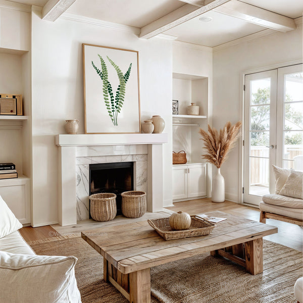 A framed watercolor painting showcases the intricate details of a fern, its small, soft green leaves rendered in subtle hues, creating a calming and elegant atmosphere in a living room with a fireplace, a rustic coffee table, and decorative accents like baskets and dried pampas grass.