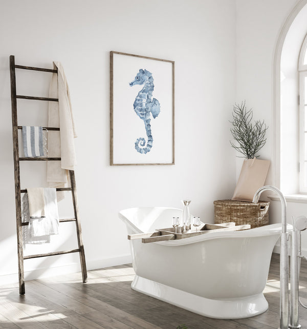 Blue seahorse wall art in a bright white bathroom with a freestanding bathtub