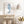 Minimalist blue seahorse print leaning on a rustic wooden console with woven baskets