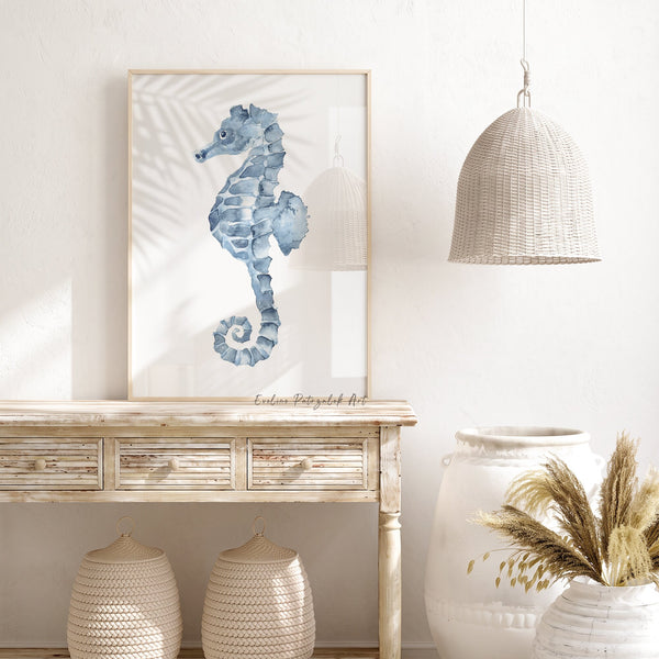 Minimalist blue seahorse print leaning on a rustic wooden console with woven baskets