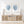 Wooden console table with decorative items and framed blue palm leaves artwork on a white wall.