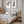 Two brown eucalyptus prints above a wooden bed in a calm Scandinavian bedroom