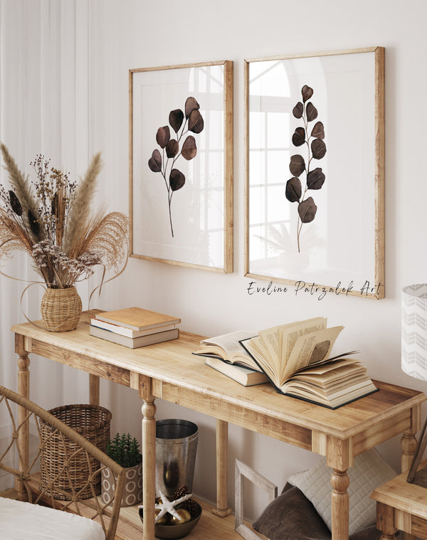 Brown watercolor eucalyptus prints above a rustic wooden console table