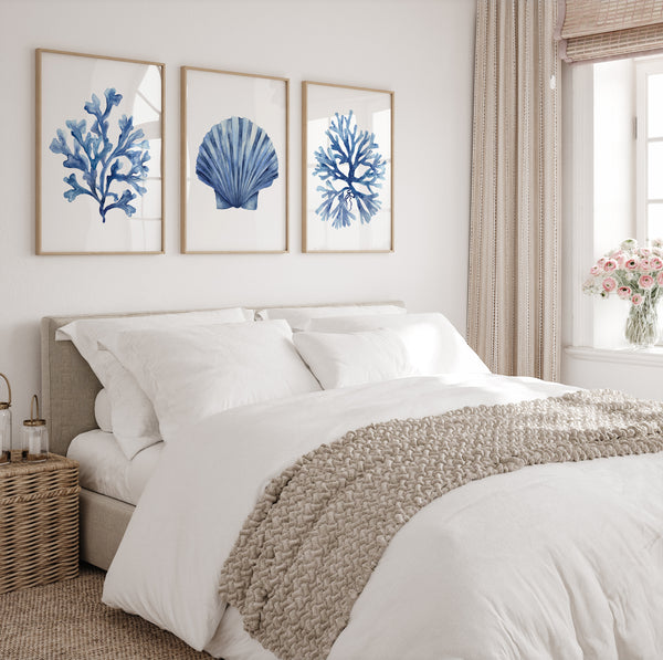 Bedroom with a bed, white bedding, and blue coral art on the wall.
