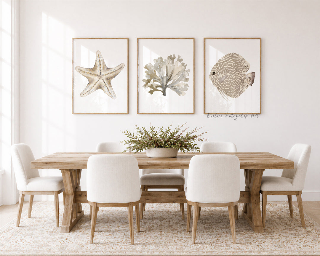 Dining room with wooden table and white chairs, featuring framed artwork of a starfish, coral, and fish on the wall.