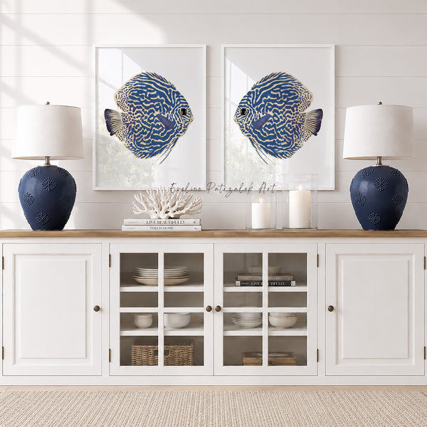 White cabinet with glass doors displaying decorative items, framed blue fish art on the wall, and two blue lamps.