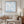 Living room with a beige sofa, decorative pillows, and a framed artwork of birds in the sky.