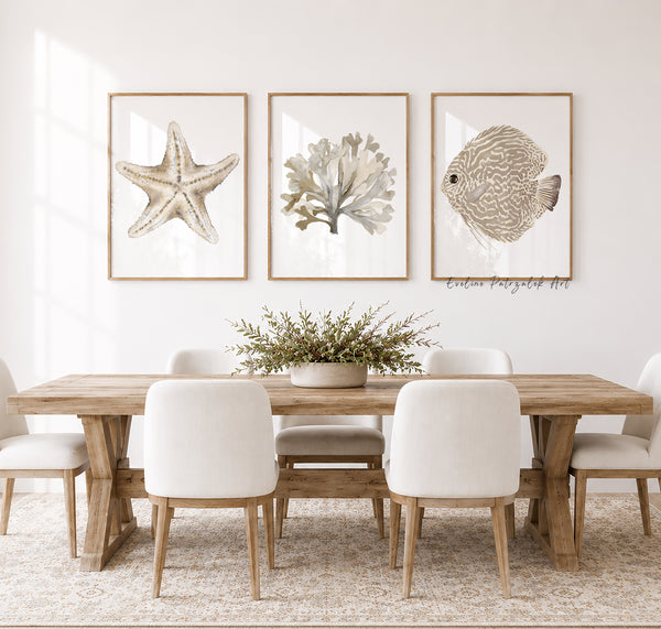 Dining room with wooden table and white chairs, featuring framed artwork of a starfish, coral, and fish in neutral colors.Pottery Barn like dinning room wall decor