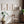 Cognac berry branch prints on a warm white wall with a wooden chair and plants