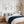 Three cognac botanical prints above a bed with a navy knitted throw