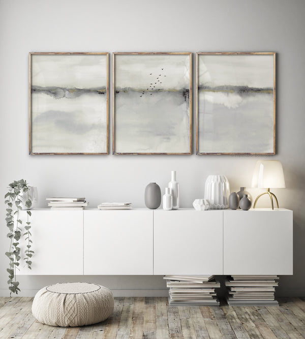 contemporary wall art set of 3 abstract prints in gray and beige hang in wooden frames above white sideboard