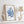 Framed blue coral art print on a white shelf with decorative items.