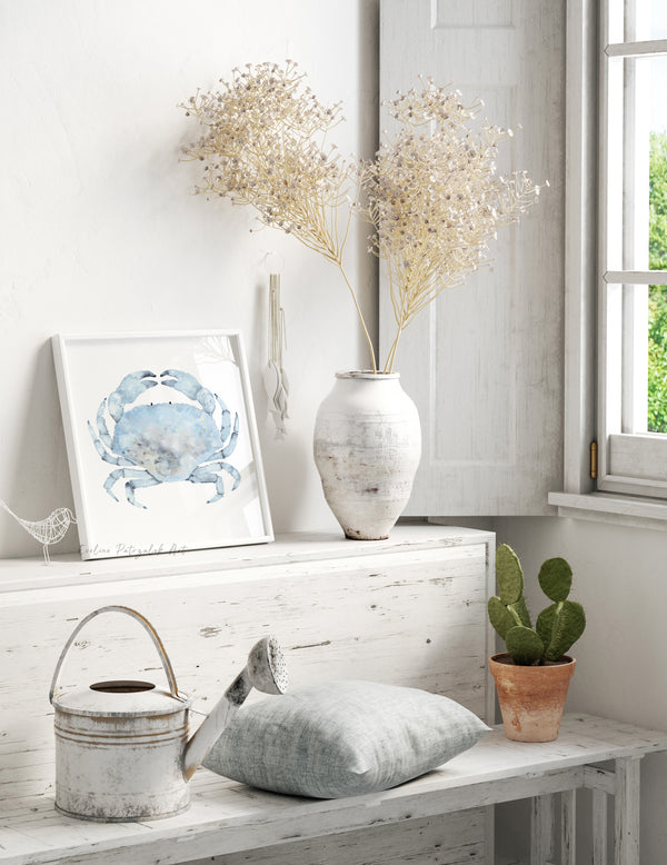 Nautical-themed room with a framed crab print, vase with dried flowers, and potted plant.