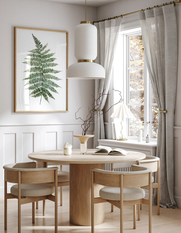 Single green watercolor fern print above a round wooden dining table