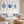 Living room with white sofa, blue pillows, and framed blue coral and shell art on the wall.