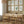 Dining room with wooden table and chairs, 8 frames with minimalist floral prints on the wall.