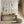 Nestled staircase with a wooden console table featuring decorative items and framed botanical prints.