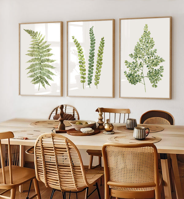Dining room with a wooden table and chairs, featuring three framed botanical prints on the wall.