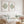 Two light green watercolor discus fish prints facing each other above a white linen sofa with mint cushions