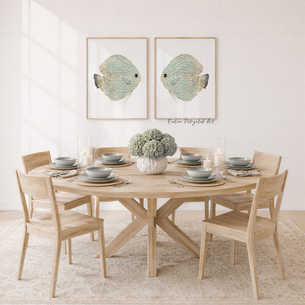 Two light green fish prints above a round wooden dining table