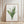Framed artwork of a floral design on a wall with wooden floor.