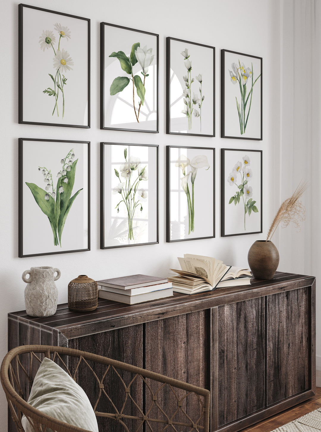 Framed botanical prints on a wall above a wooden console table with decorative items.