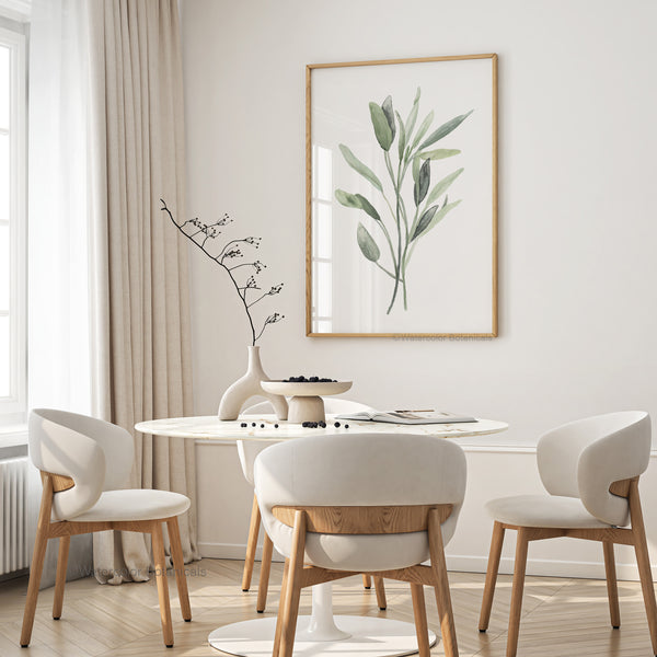 A watercolor painting of green sage leaves adds a touch of nature to a dining room with a round table, white chairs, and a white marble vase with dried branches.