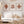 Living room with a white sofa, leaf-themed wall art, and decorative items.