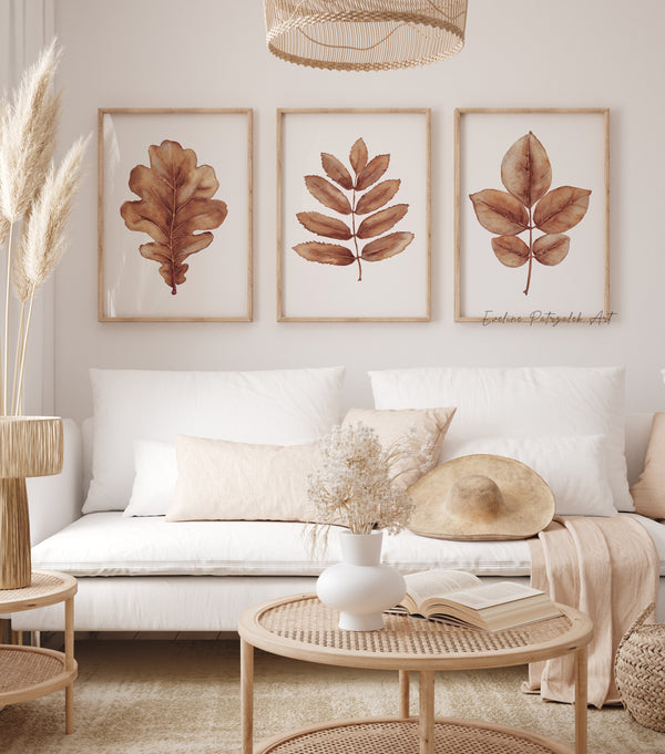 Living room with a white sofa, leaf-themed wall art, and decorative items.