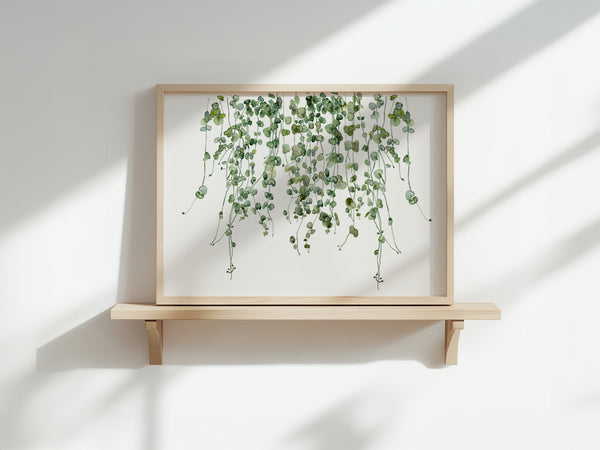 A watercolor painting of hanging green leaves adds a touch of nature to a white wall.