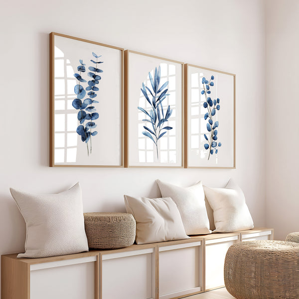 Navy blue watercolor branch prints set of 3 above a wooden bench with cream pillows