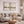 Two misty beige landscape prints with flying birds above a grey sofa in a calm living room