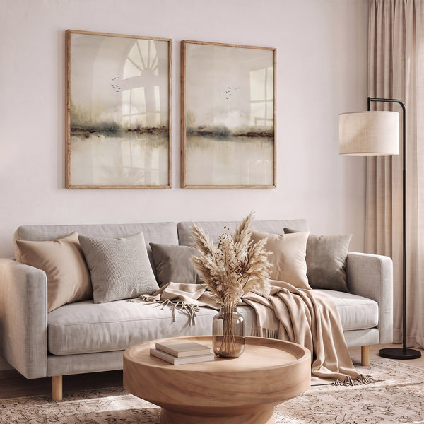 Two misty beige landscape prints with flying birds above a grey sofa in a calm living room