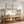 Neutral landscape wall art with birds above an oak console with two linen table lamps