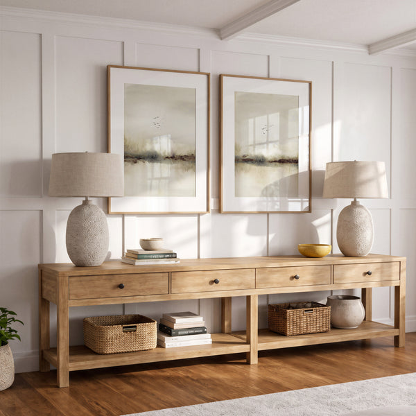 Neutral landscape wall art with birds above an oak console with two linen table lamps