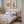 Tree slice and pine cone prints above a wooden bed in a cosy bedroom