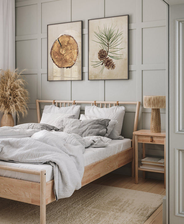 Tree slice and pine cone prints above a wooden bed in a cosy bedroom