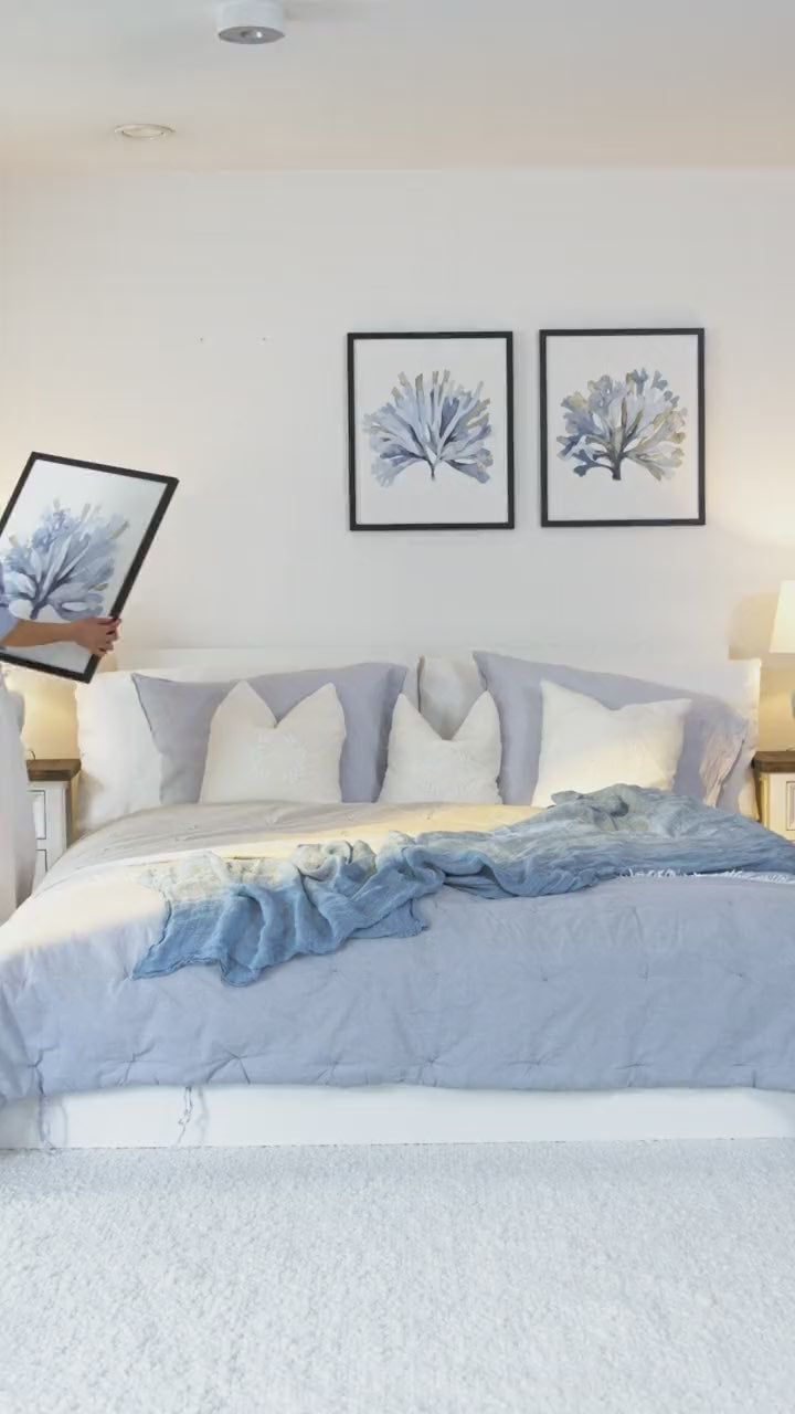Hanging framed coral watercolor prints on a living room wall